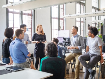 Gruppengespräch in einer Transferagentur Mehrere Menschen bei einem Gruppengespräch im Stehen