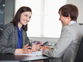 Gemeinsame Planung und konstruktive Absprache bei der Workforce-Transformation Zwei Geschäftsfrauen in einem konzentrierten Gespräch an einem Tisch.
