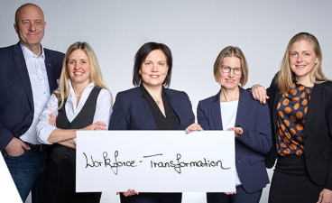 Teaser: Das Führungsteam der TRAIN GmbH mit einem Schild, auf dem Workforce-Transformation steht
