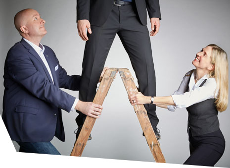 Wert, Vertrauen Inhaltsbild: Simone Körner und Reiner Hager stützen eine Leiter, auf der ein Mann steht